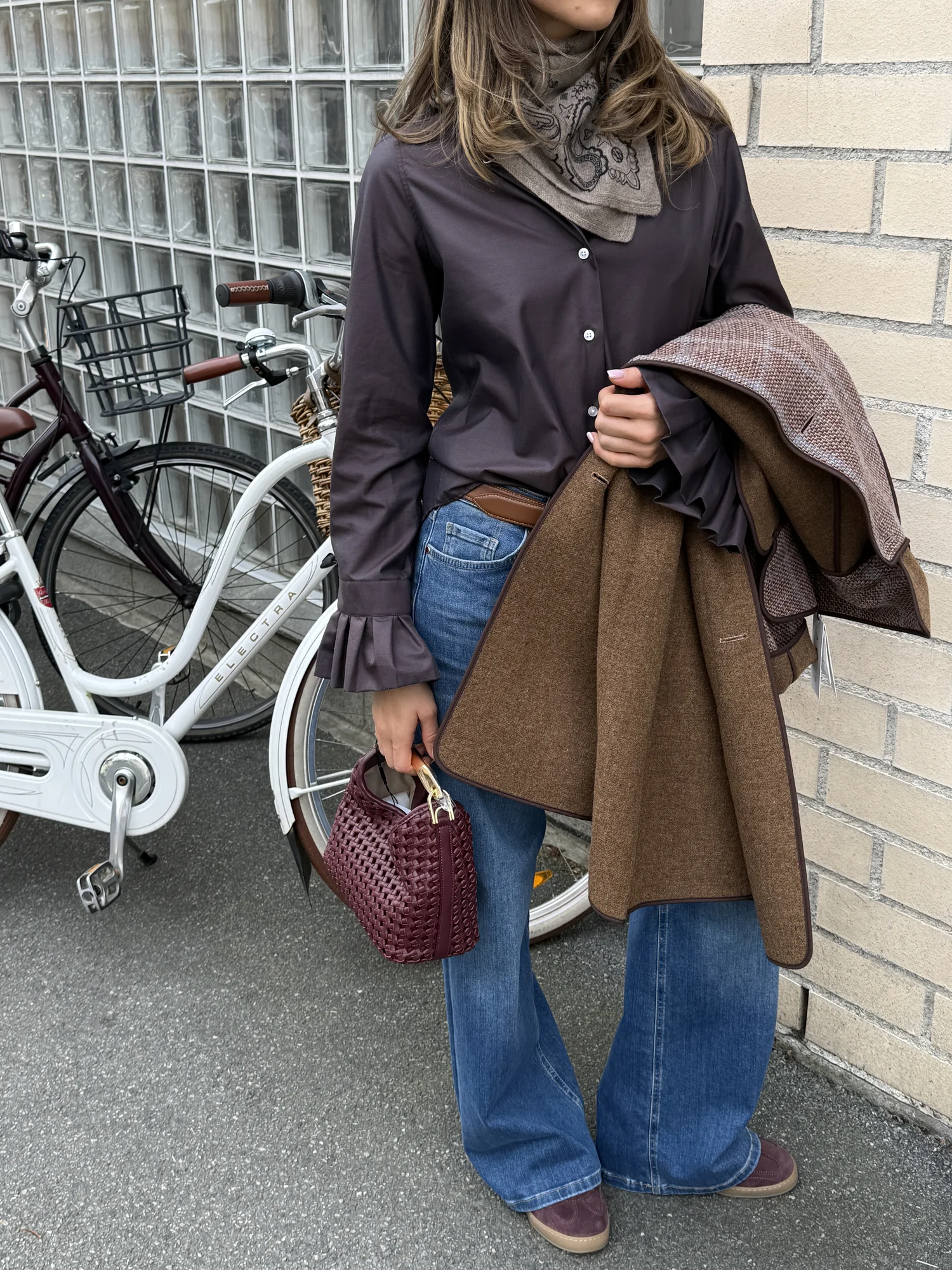Motedetaljer med brun kåpe, veske og sykkel, fotografert av Fagr